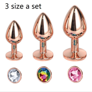 A set of three rose gold-plated aluminum anal plugs in small, medium, and large sizes, each featuring a pink heart-shaped gem on the base.