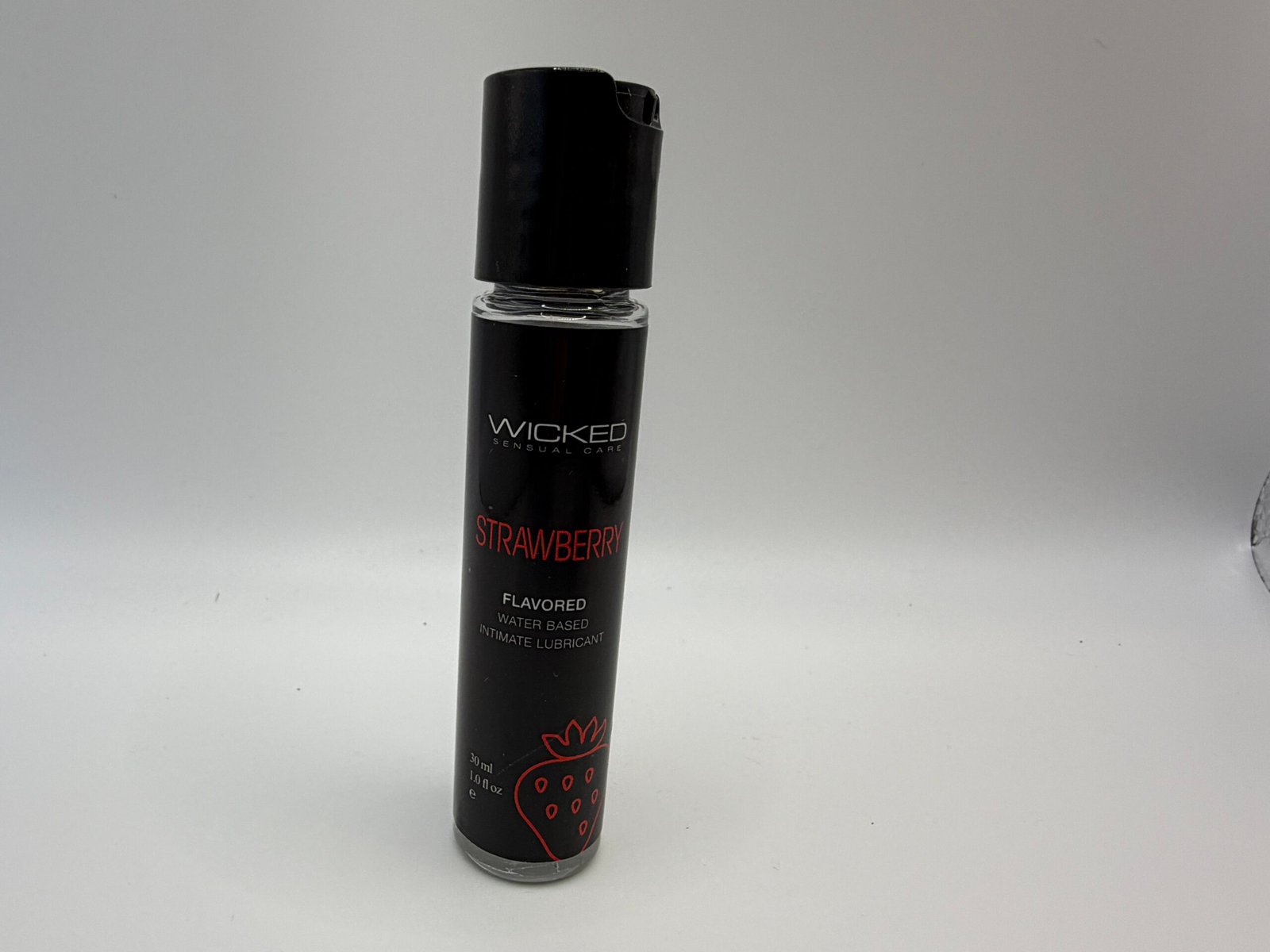 Wicked Sensual Care Strawberry flavored water-based intimate lubricant in a 1.0 fl oz bottle, featuring a vegan and paraben-free formula